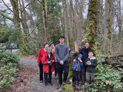 A group of volunteers posing on a path in a forest.