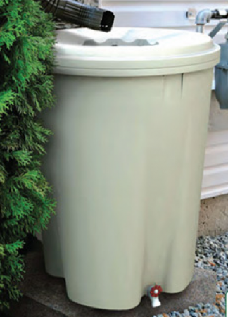 Photo of a tan rain barrel installed under a gutter.