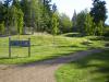 A community park featuring rolling green landscaping and a gravel pathway