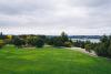An image of an expansive green park field and playground with a view overlooking Lake Washington