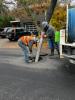 Cleaning out a catch basin with a vacuum truck.